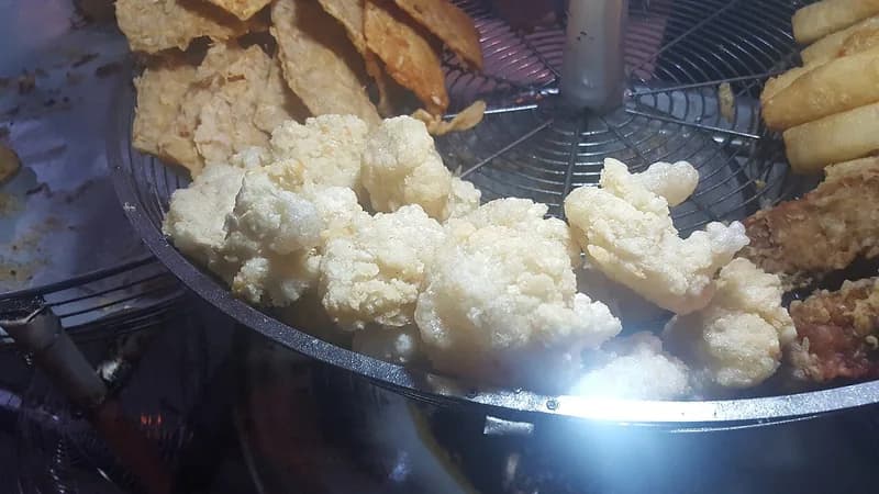 Cireng goreng putih mengembang dan renyah ditiriskan di rak kawat penjual gorengan