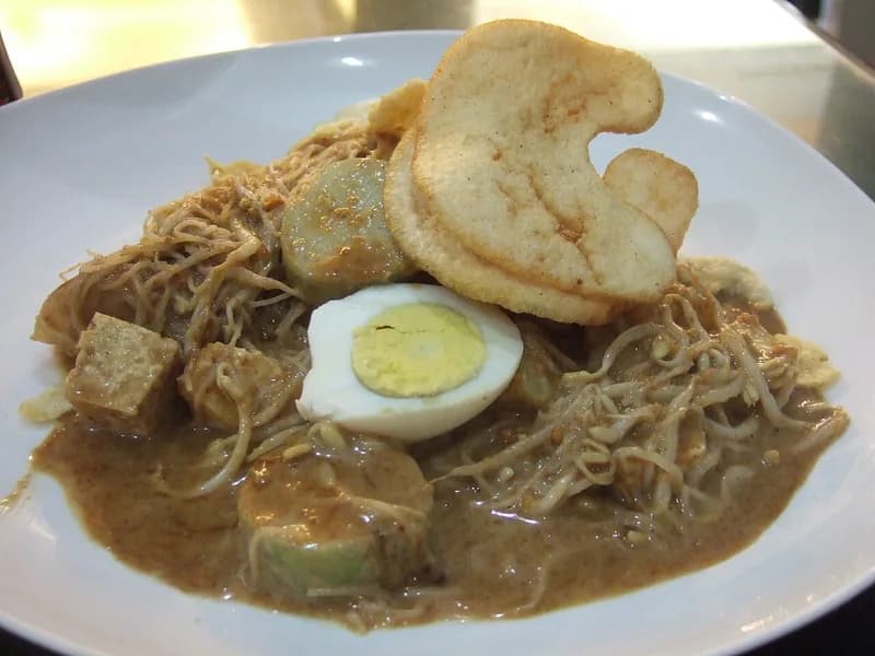 Sepiring ketoprak Jakarta berisi bihun, tahu, lontong, tauge, telur rebus, dan kerupuk dengan bumbu kacang