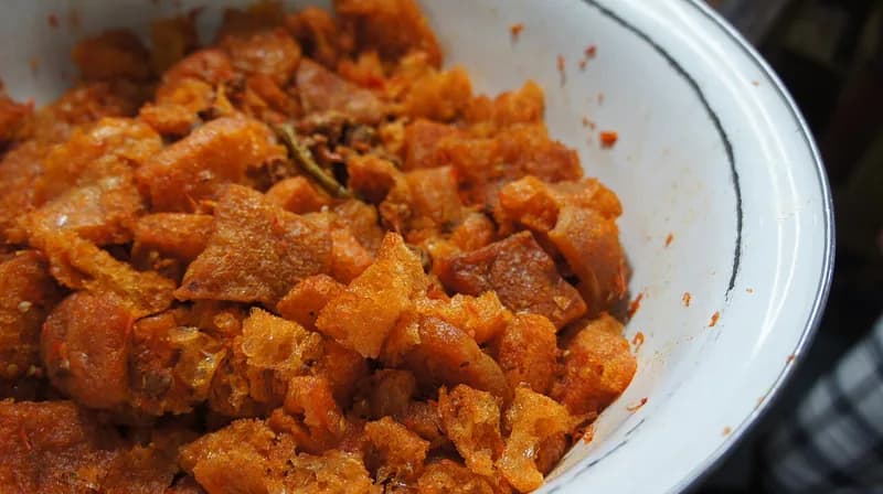 Semangkuk sambal krecek Yogyakarta, potongan kerupuk kulit sapi berbumbu merah oranye