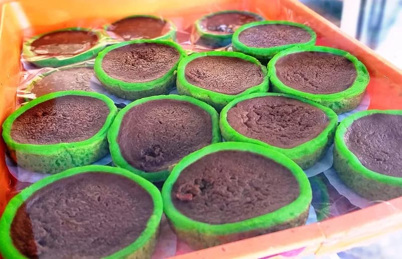 Deretan kue talam pandan gula merah berbentuk mangkuk kecil dengan pinggiran hijau di nampan