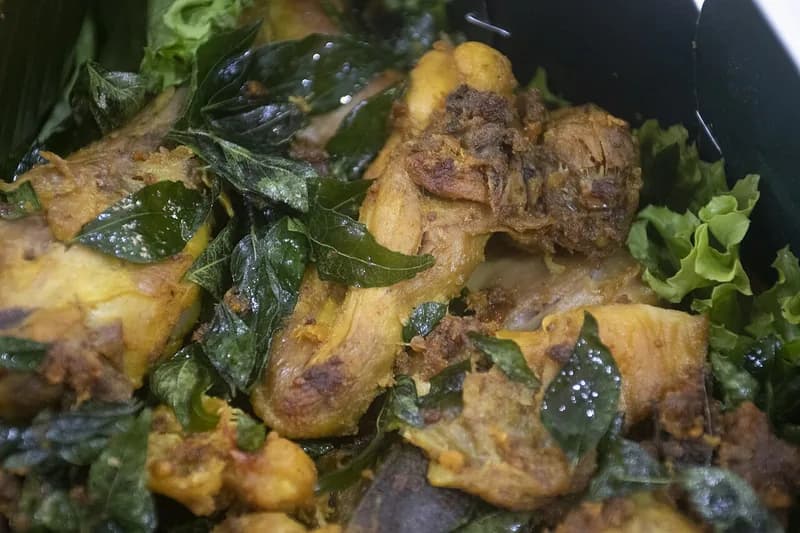 Ayam tangkap khas Aceh, potongan ayam goreng berbumbu tertutup daun kari dan daun pandan goreng