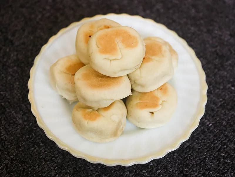 Sepiring bakpia basah khas Yogyakarta bertumpuk dengan permukaan kecokelatan di piring putih