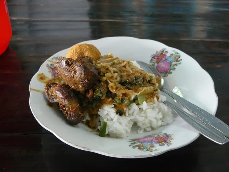 Sepiring nasi pecel dengan sayuran rebus bersiram sambal kacang, tauge, dan ati ampela goreng