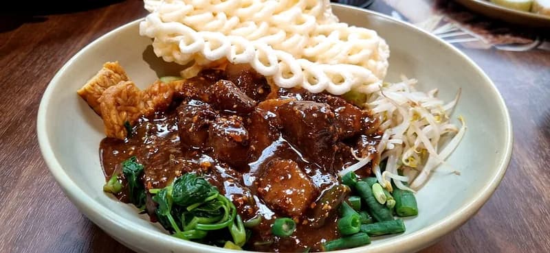 Rujak cingur bersaus petis hitam dengan kangkung, kacang panjang, tauge, tempe goreng, dan kerupuk