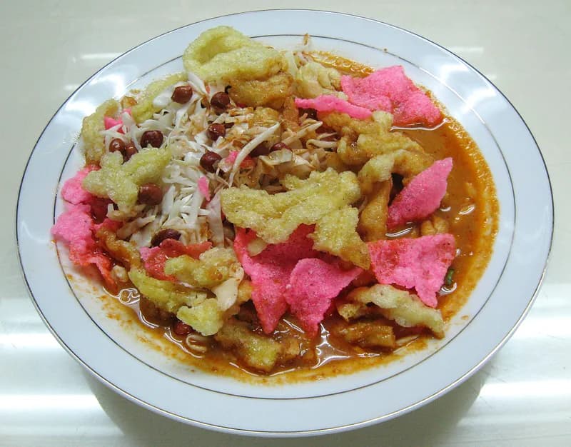 Sepiring asinan Betawi berisi kol, tauge, tahu, dan kacang tanah bertabur kerupuk mi kuning dan merah