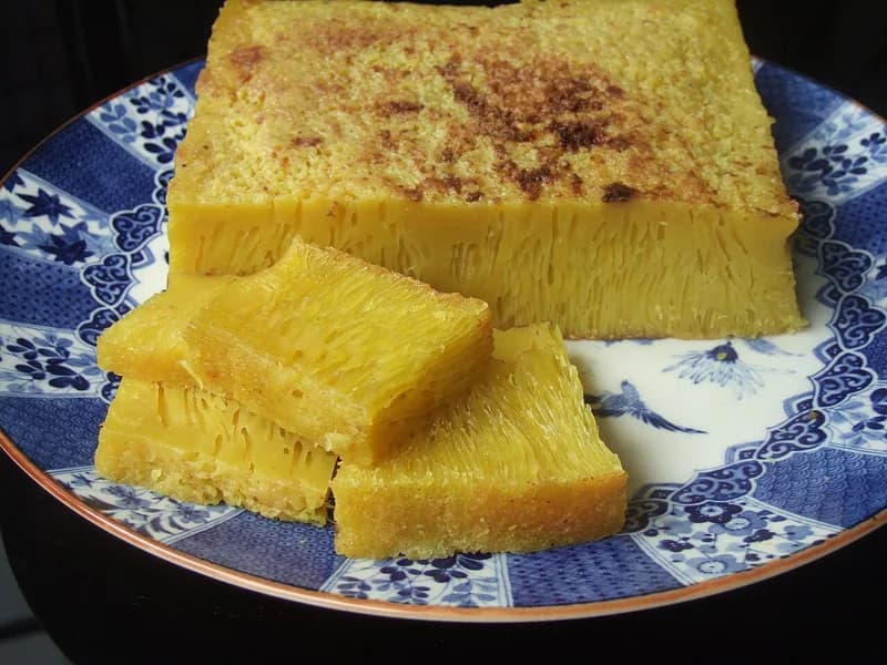 Bika ambon kuning berserat sarang lebah dengan permukaan kecokelatan di piring keramik biru putih