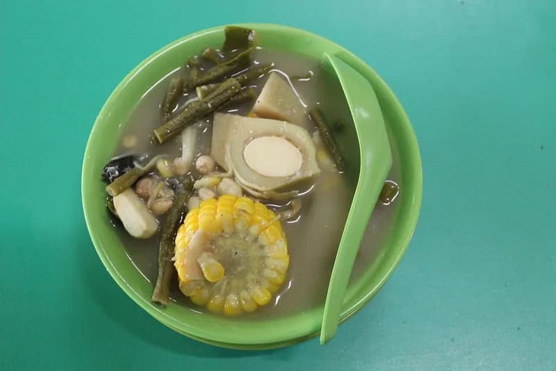 Semangkuk sayur asem berkuah bening dengan jagung manis, kacang panjang, labu siam, dan kacang tanah