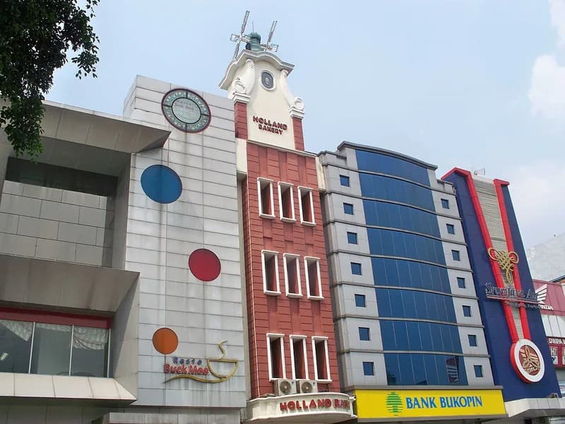 Gedung Holland Bakery berfasad bata merah dengan menara jam dan kincir angin di atapnya
