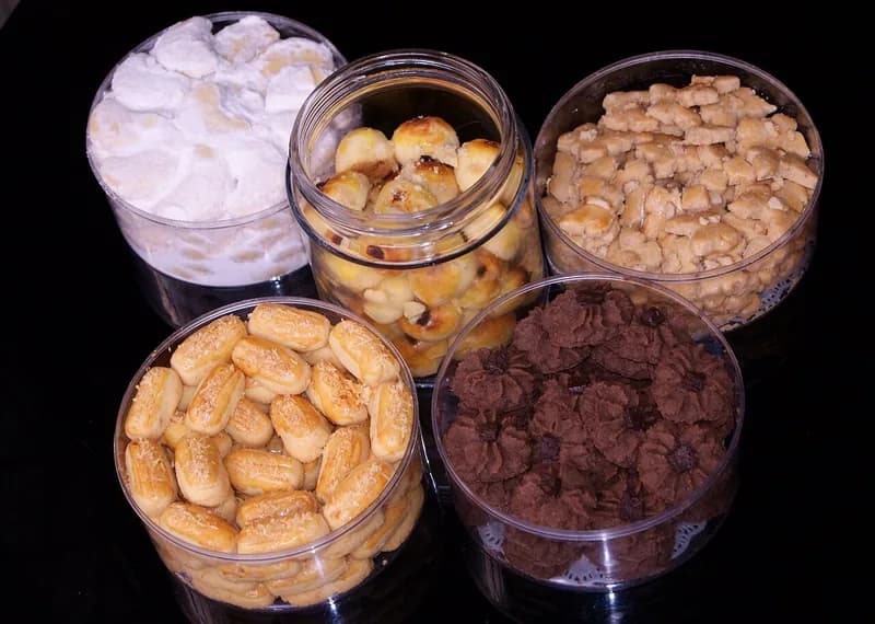 Lima toples kue lebaran berisi putri salju, nastar, kastengel, kue kacang, dan semprit cokelat