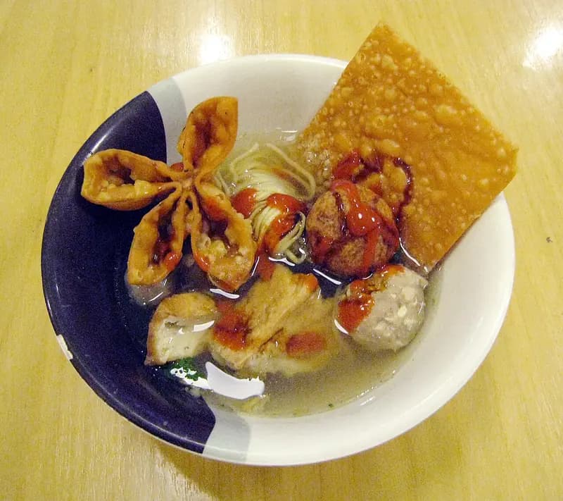 Semangkuk bakso Malang dengan pentol, mi, tahu, pangsit goreng, dan saus sambal merah