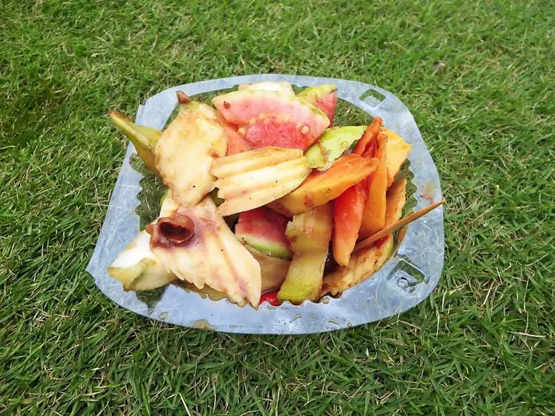 Rujak buah Bali berisi potongan jambu air, pepaya, mangga muda, dan bumbu gula merah dalam wadah plastik