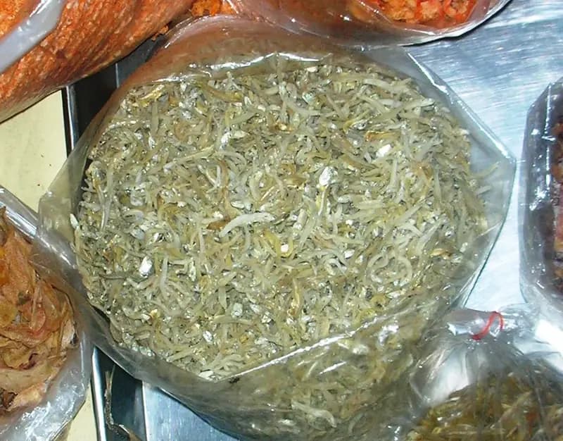 Teri nasi kering berukuran mungil berwarna putih keperakan dalam kantong plastik terbuka di lapak pasar