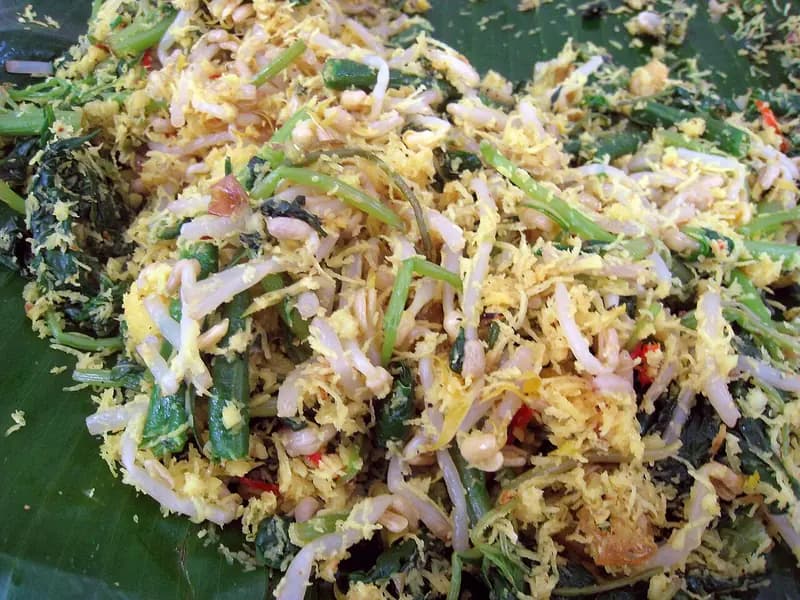 Urap sayur berisi tauge, kacang panjang, dan bayam berbalut kelapa parut berbumbu di atas daun pisang