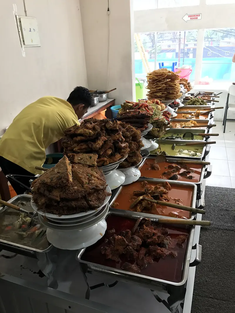 Deretan wadah lauk Minang prasmanan: rendang, gulai, ayam goreng, dan perkedel di rumah makan