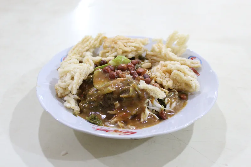 Asinan Betawi dengan sayuran, tauge, dan kacang tanah bersiram kuah kacang di bawah kerupuk mi