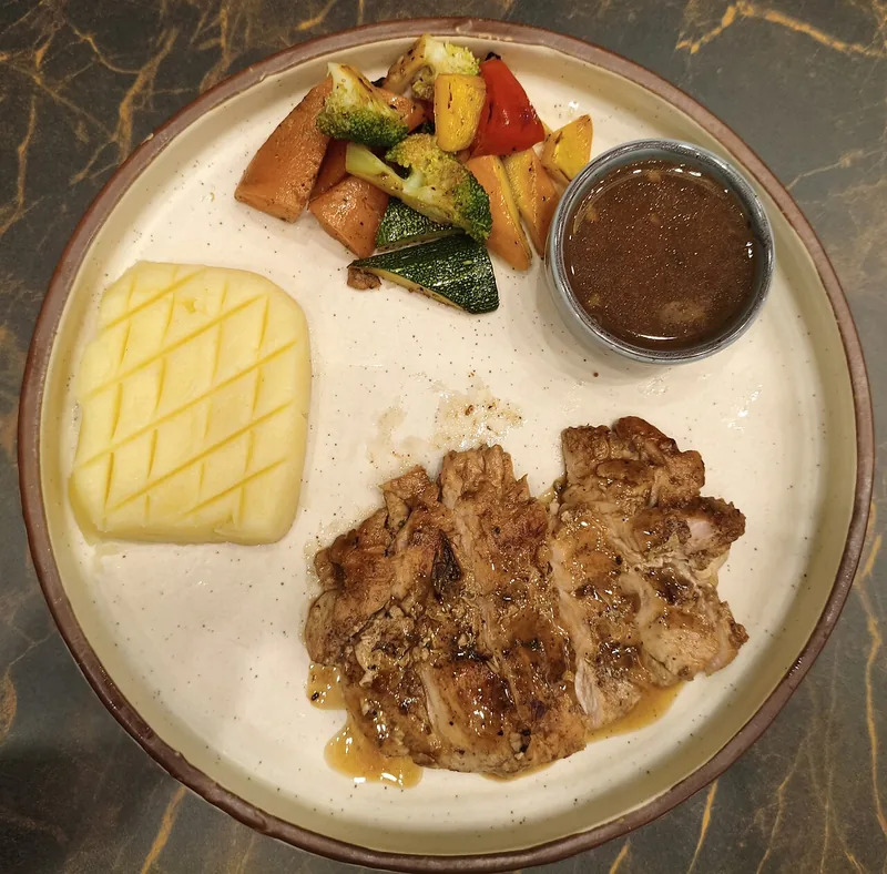 Plating steak ayam panggang dengan kentang tumbuk, sayuran panggang, dan saus cokelat dalam mangkuk kecil