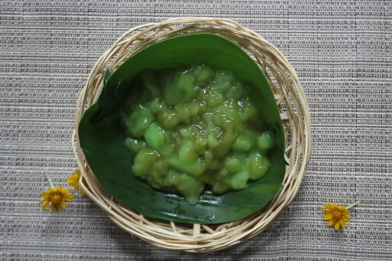Bubuh sumsum khas Bali berwarna hijau pandan dialasi daun pisang dalam keranjang anyaman bambu