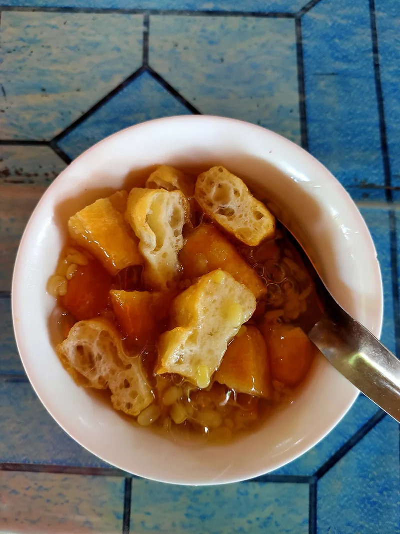 Semangkuk bubur gunting Singkawang berisi kacang hijau kupas, potongan cakwe, dan kuah manis