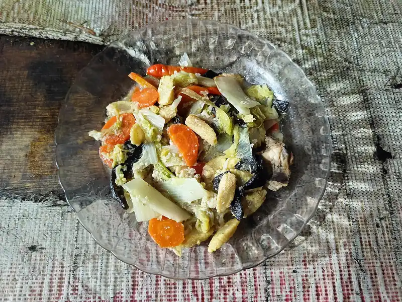 Capcay goreng kering dengan wortel, jagung muda, sawi putih, dan jamur kuping di piring kaca