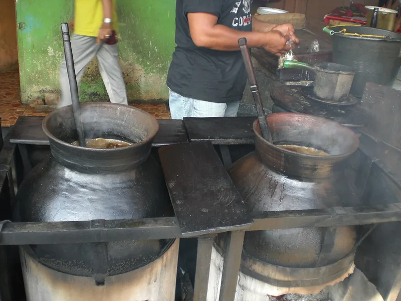 Dua kuali tanah besar berisi kuah coto Makassar yang dimasak di atas tungku