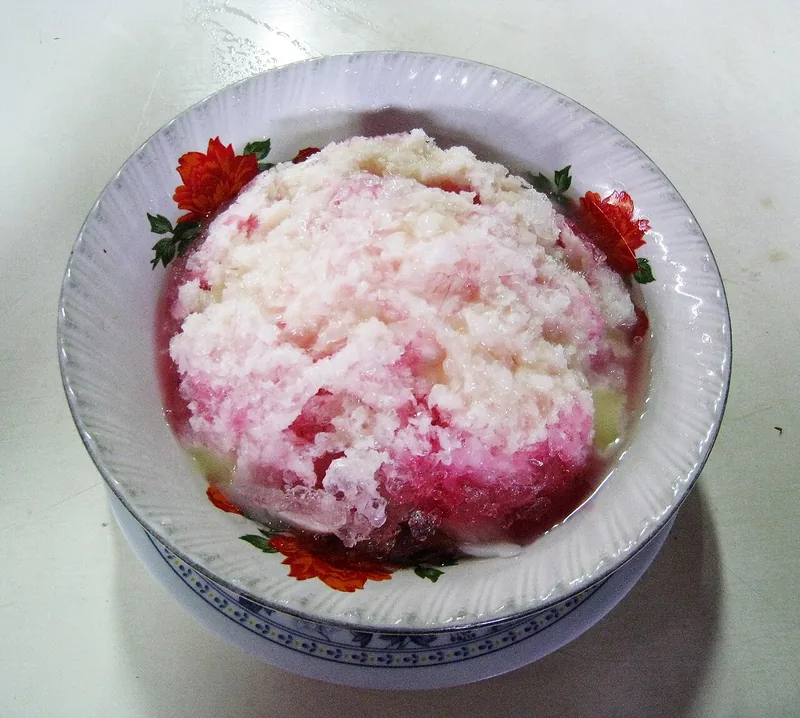 Es campur dengan gunungan es serut bersirup merah di mangkuk bermotif bunga