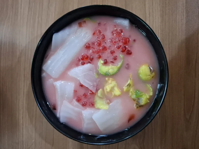 Variasi es teler dengan sagu mutiara merah, kolang-kaling, alpukat, dan kelapa muda dalam kuah merah muda