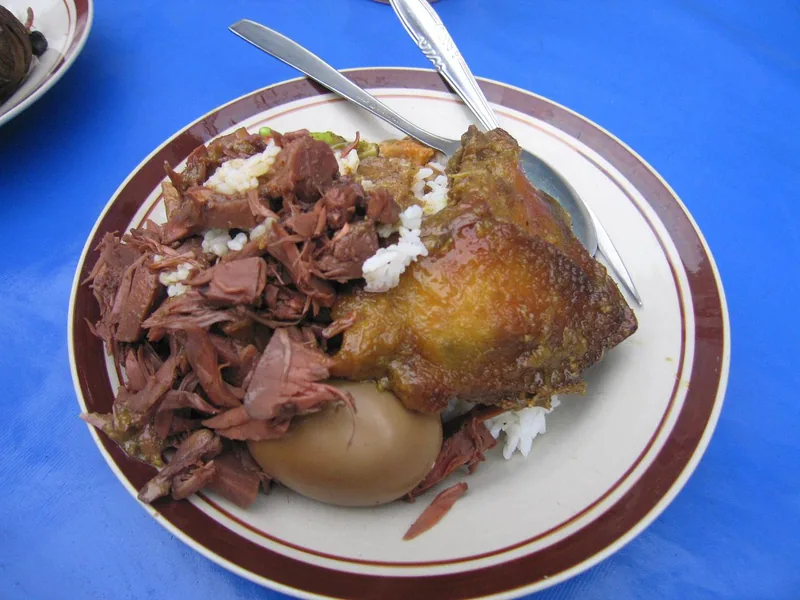 Sepiring nasi gudeg dengan ayam bacem, telur pindang cokelat, dan suwiran gudeg nangka