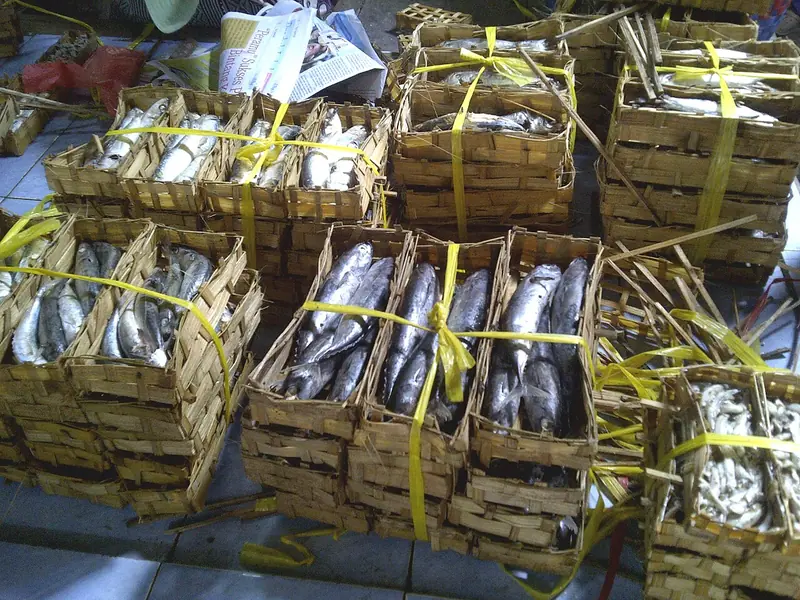 Ikan pindang tongkol tersusun dalam besek bambu yang diikat tali kuning di lapak pasar