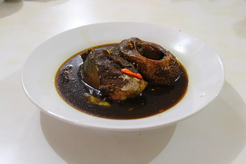 Pindang bandeng Betawi berkuah cokelat gelap dengan potongan ikan dan cabai merah di piring cekung