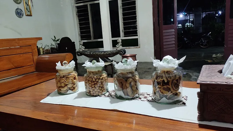 Empat toples kaca bertutup berisi aneka kue kering Lebaran tertata di atas meja ruang tamu