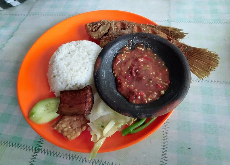 Nasi tempong khas Banyuwangi dengan ikan goreng, tempe, tahu, lalapan, dan sambal di cobek