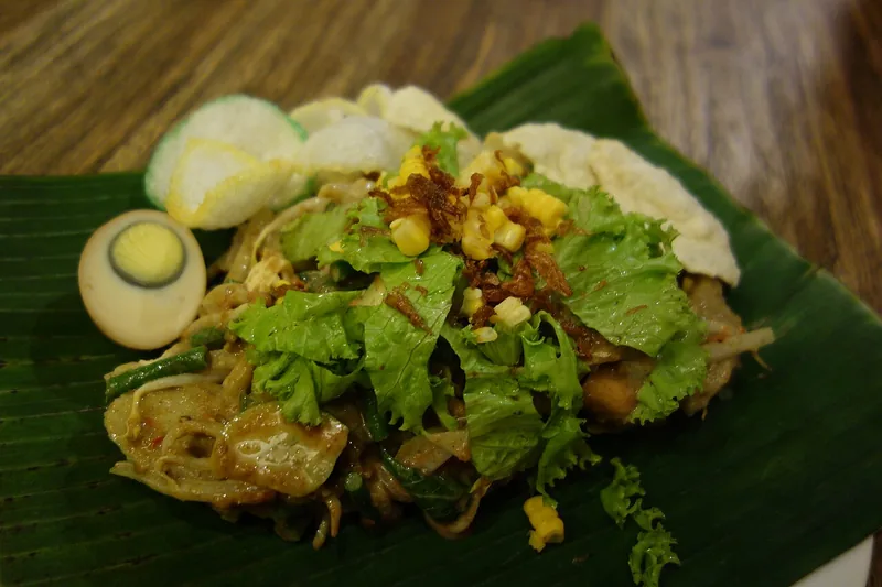 Gado-gado berisi sayuran, selada, jagung, dan telur disajikan di atas daun pisang