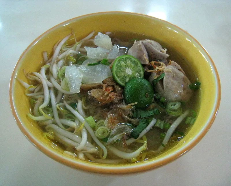 Semangkuk mie kocok Bandung dengan tauge, kikil, bakso, jeruk limau, dan bawang goreng
