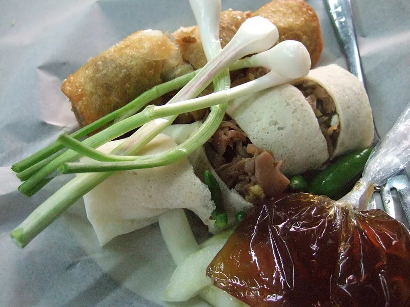 Lumpia Semarang basah dan goreng berisi rebung dengan daun bawang, cabai rawit, dan saus cokelat
