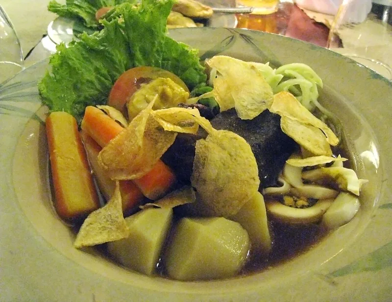 Selat Solo berisi daging, wortel, kentang, selada, dan keripik kentang dalam kuah cokelat encer