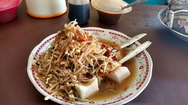 Lontong balap dengan tumpukan tauge, potongan lontong, tahu goreng, dan kuah kaldu