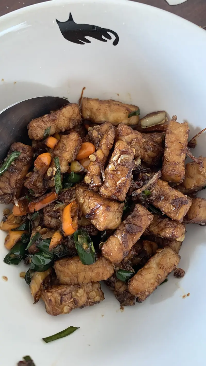 Orek tempe rumahan dengan potongan cabai hijau dan wortel dalam mangkuk putih