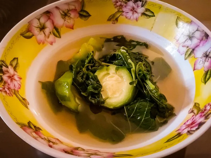 Semangkuk sayur bening berisi labu siam dan daun sayuran hijau berkuah jernih