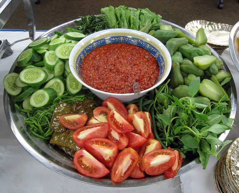 Nampan lalapan berisi irisan timun, tomat, kemangi, kacang panjang, selada, dan labu siam dengan semangkuk sambal