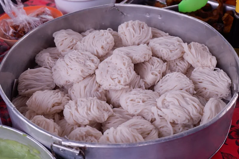 Puluhan gulungan putu mayang putih tersusun rapat di dalam talam logam