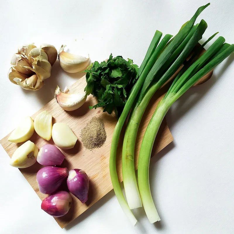Bumbu sayur sop berupa bawang putih, bawang merah, merica bubuk, seledri, dan daun bawang di talenan