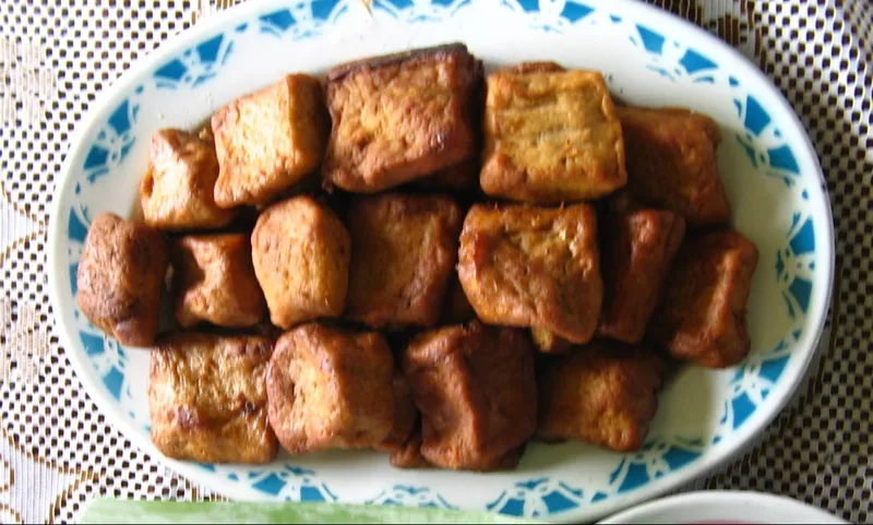 Sepiring tahu bacem potongan dadu yang sudah digoreng berwarna cokelat