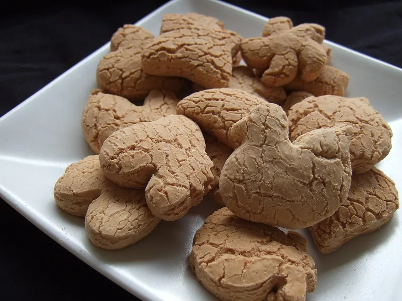 Kue bangkit sagu berbentuk hewan dengan permukaan retak halus di piring putih