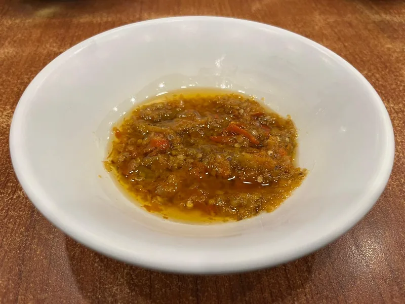 Sambal roa berserat dengan potongan cabai merah dalam genangan minyak di mangkuk putih