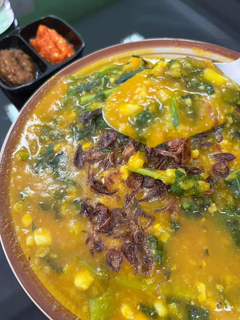 Semangkuk tinutuan atau bubur Manado dengan dua wadah kecil sambal roa dan sambal rica