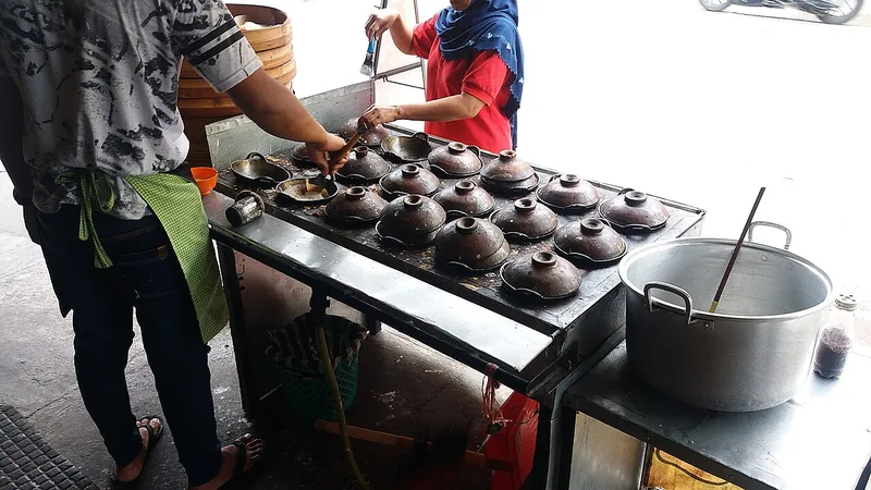 Deretan cetakan serabi tanah liat bertutup di atas tungku pedagang serabi di Klaten