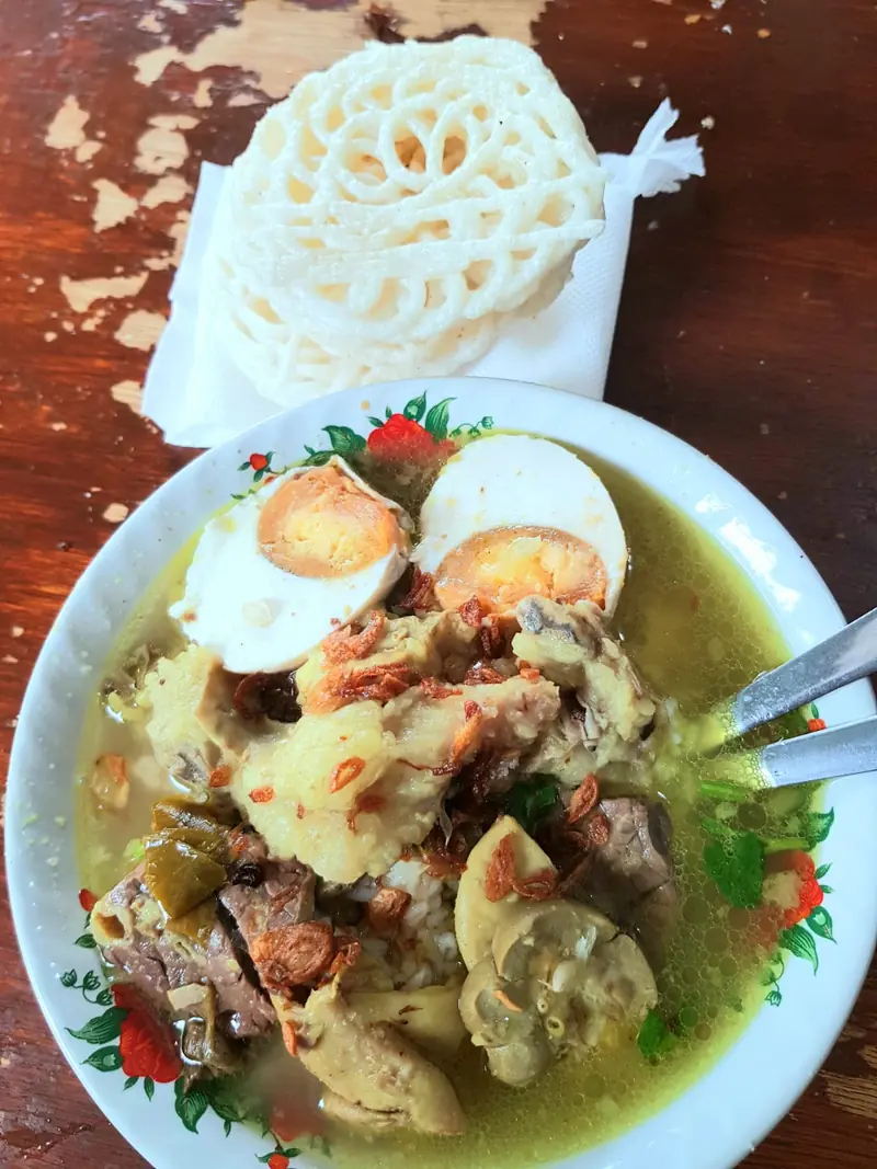 Semangkuk soto Madura daging sapi dengan telur rebus, ditemani kerupuk