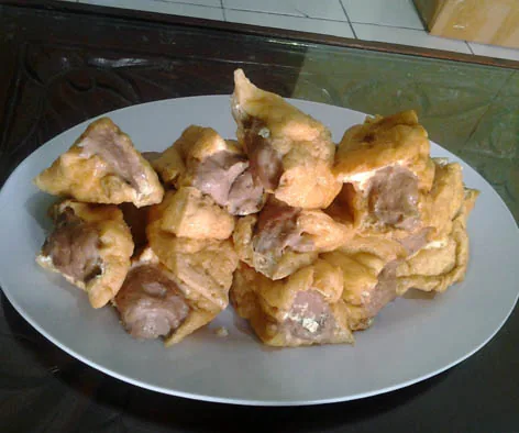 Sepiring tahu bakso goreng dengan isian adonan daging yang terlihat di bagian tengah