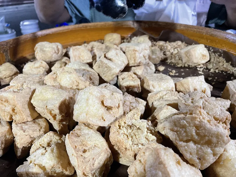 Tumpukan tahu pong goreng berongga di tampah pedagang pasar sebagai bahan dasar tahu walik