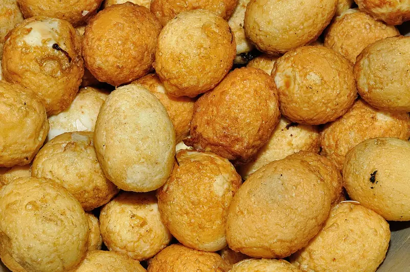 Tumpukan telur rebus yang sudah digoreng dengan kulit luar keemasan dan sedikit berkerut
